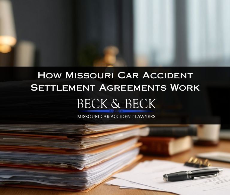 Car accident settlement agreement documents on an insurance adjustors desk related to a case handled by Beck & Beck Missouri Car Accident Lawyers