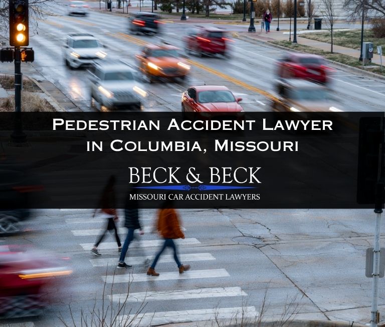 Pedestrians in a crosswalk in Columbia, Missouri with blurred traffic behind them